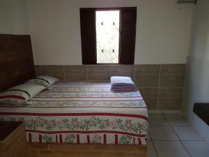a bedroom with two beds and a window at Pouso in Pirenópolis