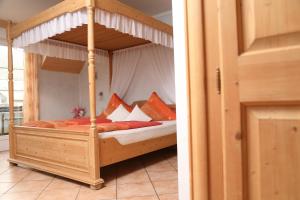 a bedroom with a wooden canopy bed with pillows at Gästehaus Knaup in Treis-Karden