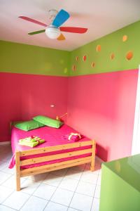 - une chambre avec un lit aux murs roses et verts dans l'établissement A casa dalla Fra, à Castelfranco Emilia
