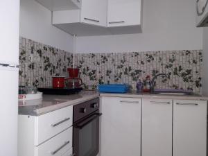 ママイアにあるStudio Sunset Violetのキッチン(白いキャビネット、黒いオーブン付)