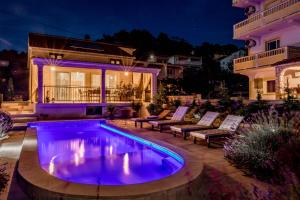 a house with a swimming pool in front of a house at Villa Bella in Banjol