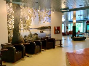 a lobby with chairs and a large painting on the wall at Hotelli Mesku Forssa in Forssa