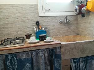 a kitchen counter with a sink and a stove at A Due Passi dal Centro in Trapani