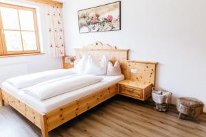 ein Schlafzimmer mit einem Holzbett und einem Fenster in der Unterkunft Ferienwohnung Bognerhof in Sankt Veit im Pongau