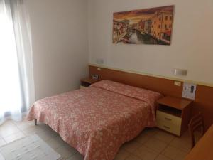 una camera da letto con un letto e un dipinto sul muro di Bar Moro 1963 a Cavallino-Treporti