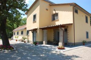 a large house with a tree in front of it at Casale delle Querce in Orvieto