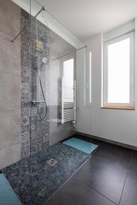 uma casa de banho com um chuveiro e uma porta de vidro em Sonnige Wohnung im Herzen von Bühl em Bühl