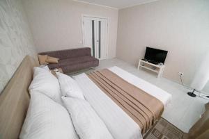 1 dormitorio con 1 cama grande y 1 sofá en PaulMarie Apartments on Kozlova, en Soligorsk
