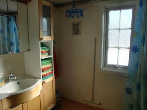 ein Bad mit einem Waschbecken und einem Fenster in der Unterkunft Bond-Gården in Fågelmara