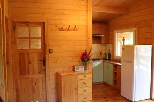 a kitchen in a log cabin with a refrigerator at Koło Żółwia in Gąski