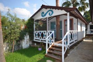 ein kleines Haus mit einer Veranda und einer Treppe in der Unterkunft Blu Brezza Marine Hotel in Hisarönü