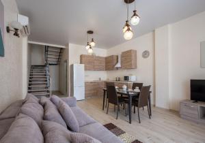 a living room and kitchen with a couch and a table at GOLD BUGAZZ in Gribovka