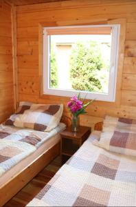two beds in a room with a window and flowers at Koło Żółwia in Gąski +27 photos