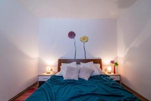 una camera da letto con un letto con due lampade e fiori sul muro di Holiday Home Carla and Dajana a Veliki Vareški Altre 45 foto