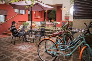 mężczyzna siedzący przy stole obok rowerów w obiekcie Viajero Posada B&B w mieście Colonia del Sacramento