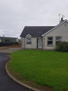 Una casa con un césped verde delante de ella. en Portrush Holiday Haven, en Portrush