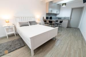 1 dormitorio con 1 cama blanca grande y cocina en Casa do Foral, en Ponte de Lima