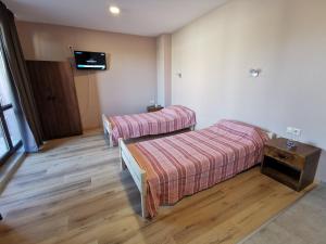 a room with two beds and a tv on the wall at Kazak in Obzor