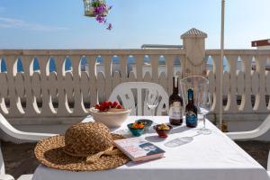 - une table avec un chapeau et 2 bouteilles de vin dans l'établissement Rifugio Delle Nereidi, à Marina di Mancaversa