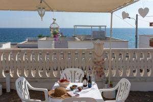 d'une table et de chaises sur un balcon donnant sur l'océan. dans l'établissement Rifugio Delle Nereidi, à Marina di Mancaversa
