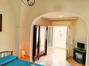 カストロ・ディ・レッチェにあるCentro Storico di Castro Marinaのベッドルーム1室(ベッド1台付)、アーチ型の出入り口が備わります。