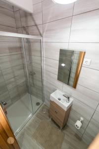 a bathroom with a shower and a sink and a mirror at Casa do Foral in Ponte de Lima