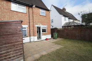 un patio trasero de una casa con una valla en Windsor House en Slough