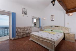 a bedroom with a bed and a view of the ocean at Holiday home Viki1 - next to sea in Podobuče