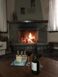 マリア・ダ・フェーにあるPousada Maria da Féのワイン1本、暖炉付きのテーブルにグラス2杯