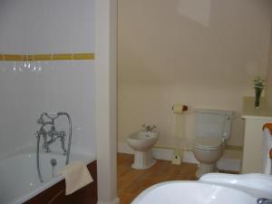 a bathroom with a tub and a toilet and a sink at Home farm cottage Guest House in Norwich