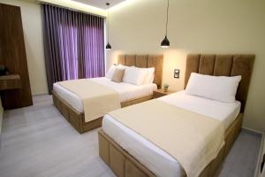 pokój hotelowy z 2 łóżkami i oknem w obiekcie Hotel Sunway w mieście Ksamil