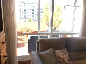 sala de estar con sofá y ventana grande en HyP - El Oasis del Centro, en Pontevedra