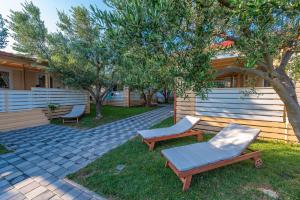 a patio with two lounge chairs and a tree at Camp Bepo in Pakoštane