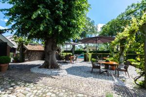 a table and chairs under a tree with an umbrella at Hoeve de Eshof in Norg