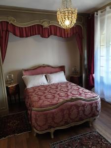 una camera con letto king-size e lampadario a braccio di Villa La Fontaine Sarlat La Caneda a Sarlat-la-Canéda