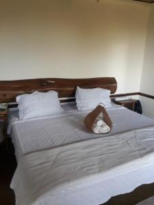 a large white bed with two towels on it at Chale Vista Encantada in Lavras Novas
