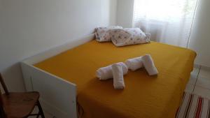 Una cama con dos toallas enrolladas encima. en Adega do Batista en Calheta