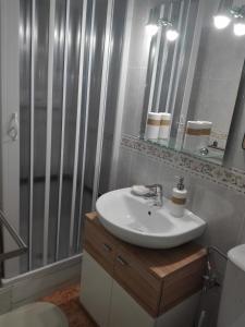La salle de bains est pourvue d'un lavabo blanc et d'une douche. dans l'établissement UN ESPACIO DONDE CREAR GRANDES RECUERDOS, à Calella