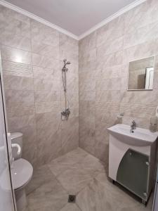 a bathroom with a shower and a sink and a toilet at Kazak in Obzor