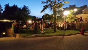 grupa ludzi stojących w trawie w nocy w obiekcie Bed And Breakfast Olimpia w mieście San Salvatore Monferrato +37 zdjęć
