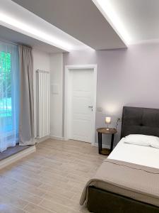 een witte slaapkamer met een bed en een raam bij B&B Villa Paradiso in Urbino