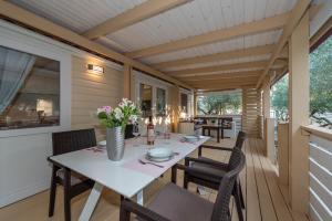 una sala da pranzo con tavolo e sedie su una terrazza di Camp Port a Pakoštane