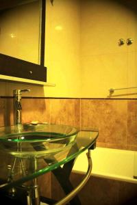 W łazience znajduje się szklana umywalka i lustro. w obiekcie Hotel Aire de Patagonia w mieście Río Gallegos