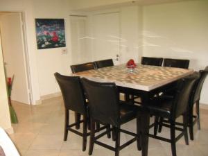a dining room table with black chairs around it at Resort Style In Aventura Florida in Aventura