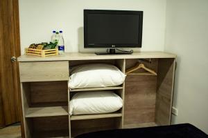 a tv sitting on top of a shelf with a monitor at El Reloj Casa Hotel in Filandia