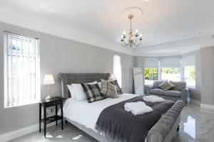 1 dormitorio blanco con 1 cama grande y 1 sofá en Chestnut House, Sleeps 11, Beautiful, spacious & comfortable, en Belfast