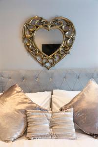 a heart shaped mirror on a wall above a bed at Chestnut House, Sleeps 11, Beautiful, spacious & comfortable in Belfast