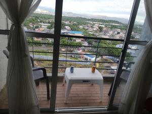 a balcony with a table and a view of a city at Reserva del Peñon in Girardot