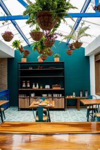 uma sala com mesas e vasos de plantas no tecto em El Reloj Casa Hotel em Filandia