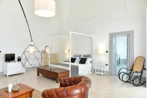 sala de estar con cama y sofá en Dimora Duchessina Suites de Charme, en Minervino di Lecce